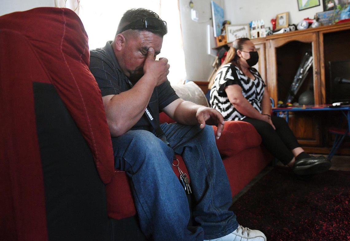 Juan Cruz bows his head as his mother, Claudia Medina, right, talks about her husband, Pedro Cruz Mendoza, who died from COVID-19, during an interview at the family’s home in Lemoore on April 6, 2021 .