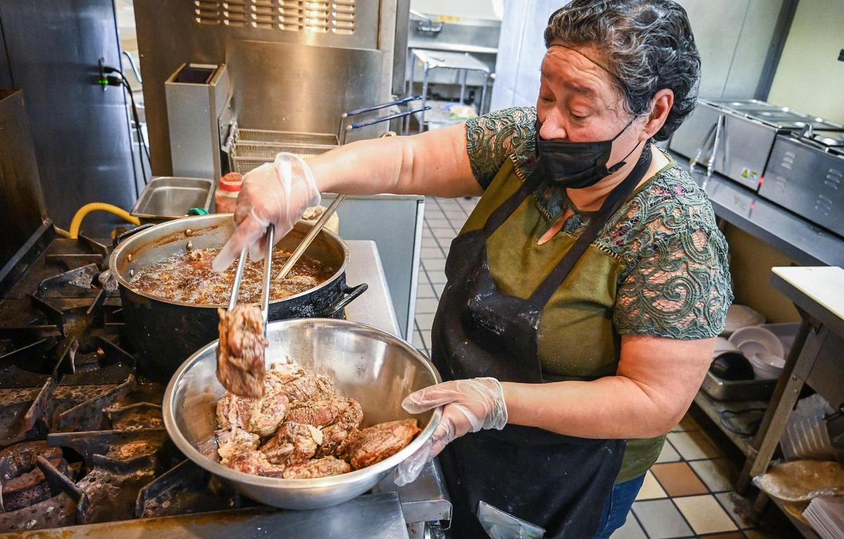 Carmen Centeno Ramirez prepares carnitas at CDT Cocina now open in the Tower Theatre building, on Thursday, May 19, 2022.