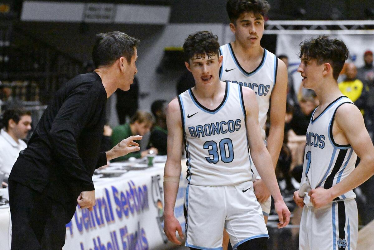 Clovis North head coach Tony Amundsen, left, talks to Connor Amundsen, center, in the closing minutes against St. Joseph in the Central Section Division I basketball championship Saturday, Feb. 24, 2024 at Selland Arena in Fresno.