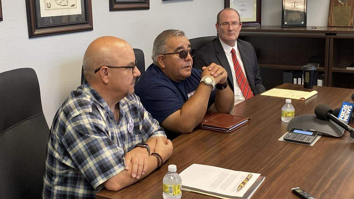 John Jones, left, and Ramon Figueroa, center, hold a news conference with Tulare County Supervising District Deputy Attorney John Sliney in Visalia on Tuesday, Aug. 23, 2022.