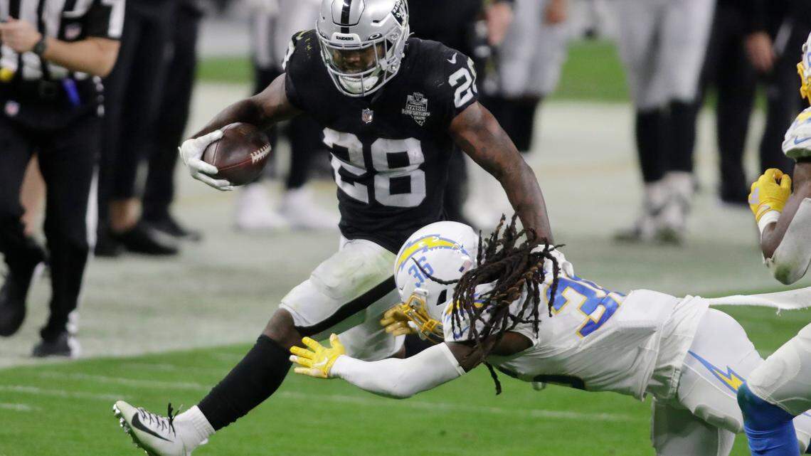 Las Vegas Raiders running back Josh Jacobs (28) runs against Los Angeles Chargers safety Jahleel Addae (36) during the second half of an NFL football game, Thursday, Dec. 17, 2020, in Las Vegas.