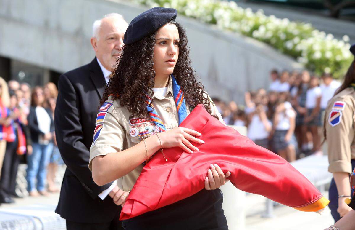 A member of the Homenetmen Fresno Sassoon Scout Chapter holds the Armenian flag at the annual Armenian genocide commemoration and flag-raising ceremony at Fresno City Hall on April 24, 2025.
