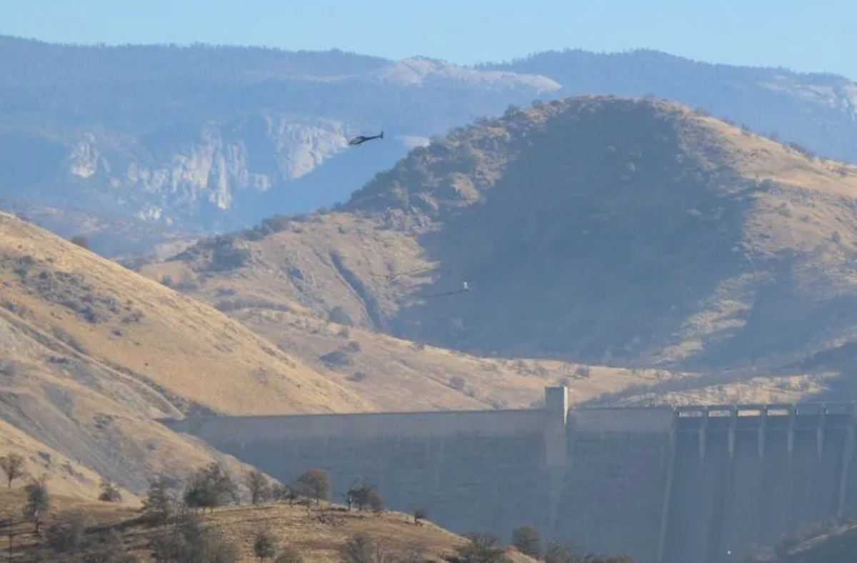 A helicopter drags a hoop used to send and receive electromagnetic signals into the earth above Pine Flat Dam. The process is used to search for ancient river channels for better groundwater recharge.