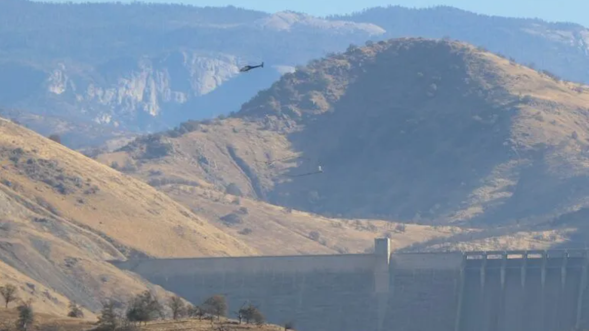 A helicopter drags a hoop used to send and receive electromagnetic signals into the earth above Pine Flat Dam. The process is used to search for ancient river channels for better groundwater recharge.