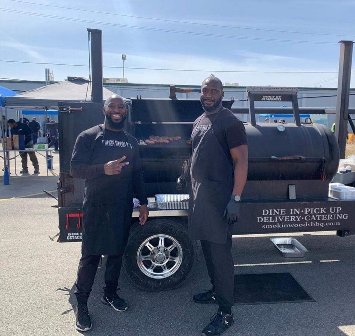 James Woodard, left, and brother Joshua are pictured in front of a Smokin Woods BBQ smoker. Several members of the family are involved in the business, which is planning a location in Fresno.