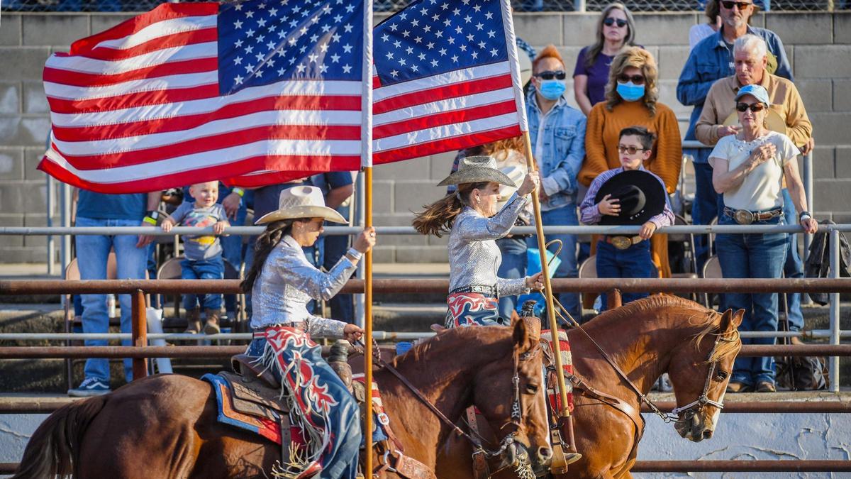 Riders carry American flags during the opening ceremonies for day one of Professional Rodeo Cowboys Association action at the Clovis Rodeo on Thursday, April 23, 2021.