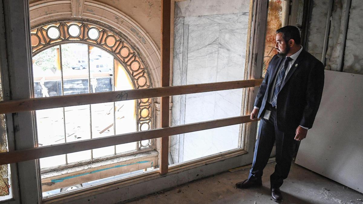 Fresno city councilmember Miguel Arias looks down to the grand entrance from the second floor of the historic Hotel Fresno, currently being renovated as an affordable apartment housing project, on Thursday, Oct. 7, 2021.