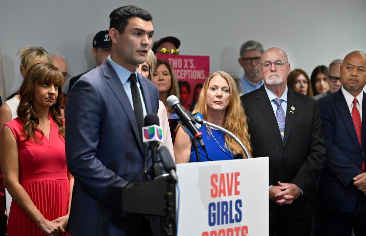 Clovis mayor pro tem Diane Pearce, far left, Clovis councilmember Drew Bessinger, second from far right and Clovis mayor Vong Mouanoutoua, far right, listen as Republican assemblyman David Tangipa speaks at a press conference pushing back against the inclusion of a transgender athlete at the CIF State Track & Field Championships Thursday, May 29, 2025 in Clovis.
