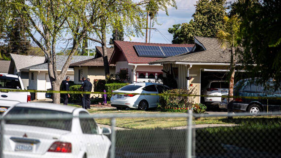 Police tape off a home where a car crashed after the driver was injured during a car-to-car shooting Sunday, March 20, 2022, in Fresno, California. Investigators announced later that the man had died.