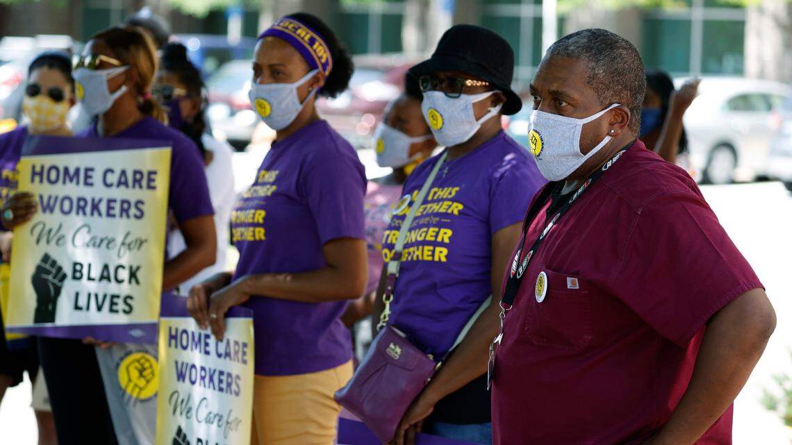Lawrence Chapman, front, listens to the speaker with other attendees after kneeling for eight minutes and 46 seconds in honor of George Floyd during a gathering outside the Kaiser Permanente health care facility Monday, July 20, 2020, in east Denver. Colorado janitors, security and health-care workers took part in the effort, which matched similar actions staged across the country to support the movement for Black lives.