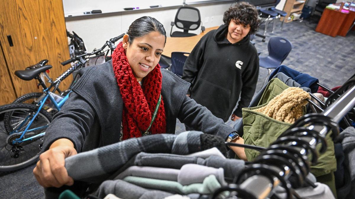 Emma Chavez, a community school coordinator at Jackson Elementary School in Fresno, looks for a new jacket or sweatshirt to give to student Giovanni Ruiz Gonzalez through the community school program on Wednesday, Dec. 18, 2024.