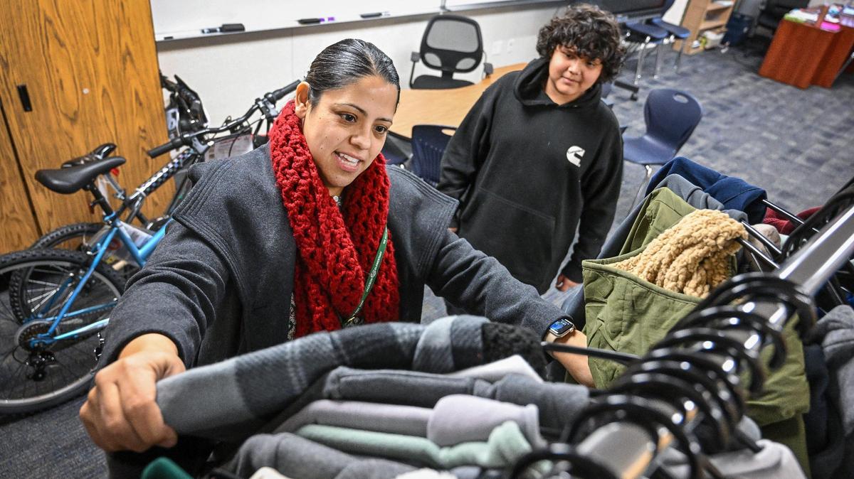 Emma Chavez, a community school coordinator at Jackson Elementary School in Fresno, looks for a new jacket or sweatshirt to give to student Giovanni Ruiz Gonzalez through the community school program on Wednesday, Dec. 18, 2024.
