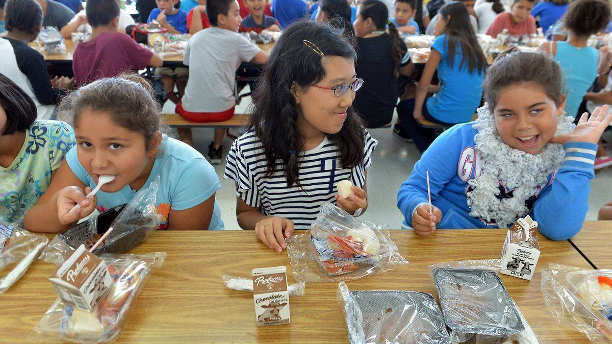 From left, Pearla Lopez, 9, Japanese student Wakana Sugimoto, 10, and Arieaunna Loredo, 10, enjoy lunch together at Holland Elementary School in Fresno in this 2016 photo.