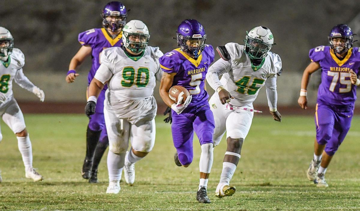 Fresno’s Lee Qae Rice takes the ball on a first down run up the middle as the Roosevelt defense gives chase during the 92nd annual Little Big Game between the two schools at Ratcliffe Stadium in Fresno on Friday, Oct. 28, 2022.