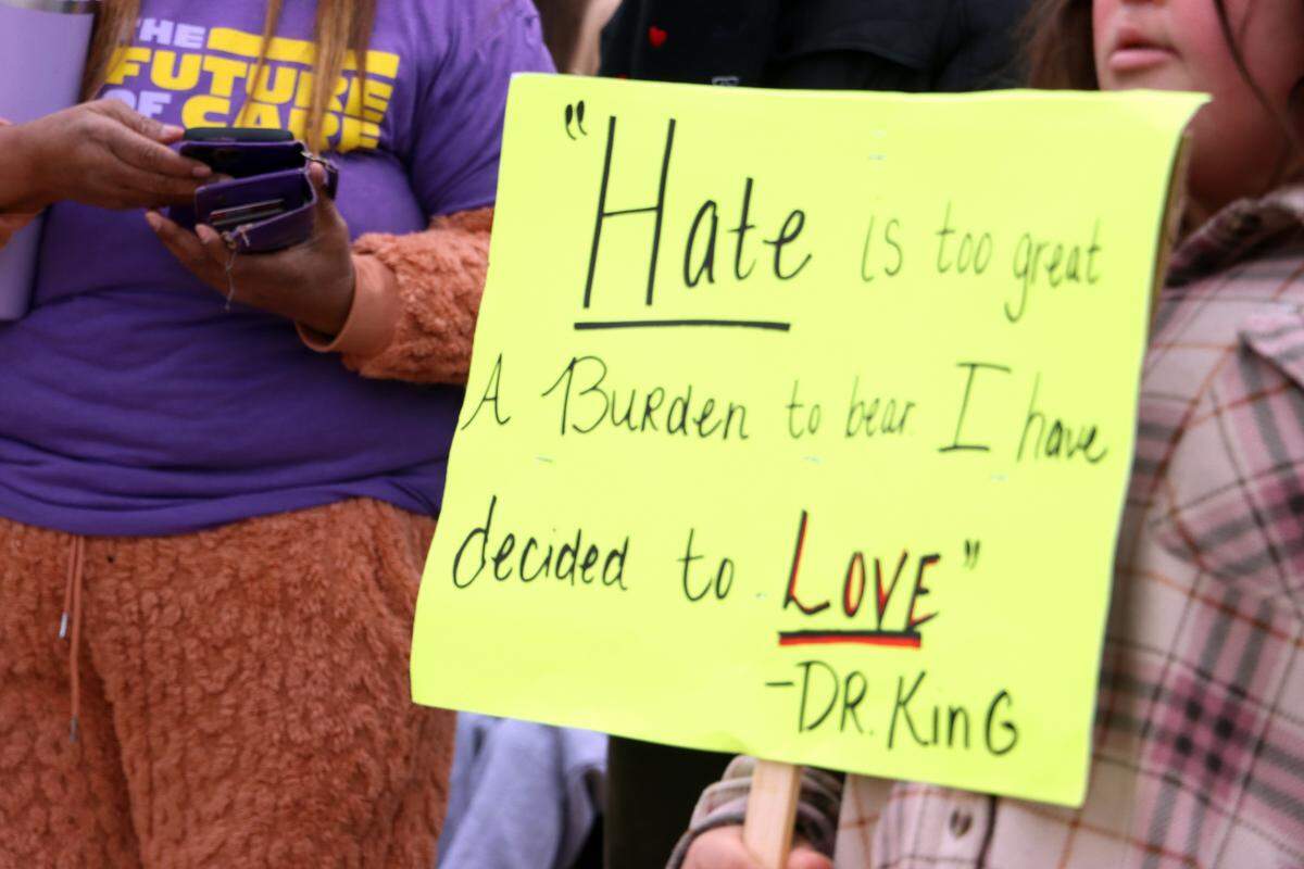 A girl carries a sign outside Fresno City Hall during the 41st annual Martin Luther King Jr. March on Jan. 20, 2025.