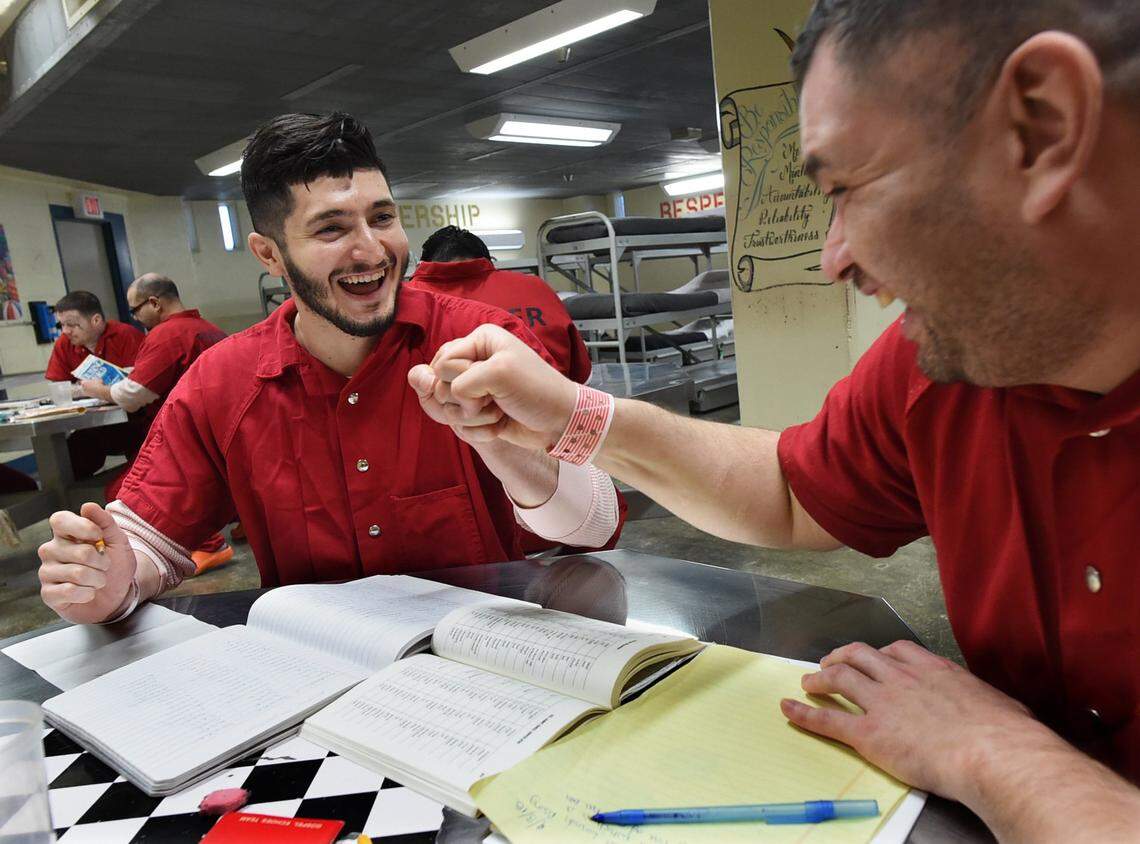 Fresno County Jail inmates Angel S., left, fist-bumps Carlos G., Fresno County Jail inmate, right, while working on their English lessons as part of jail's Transition from Jail to Community program.