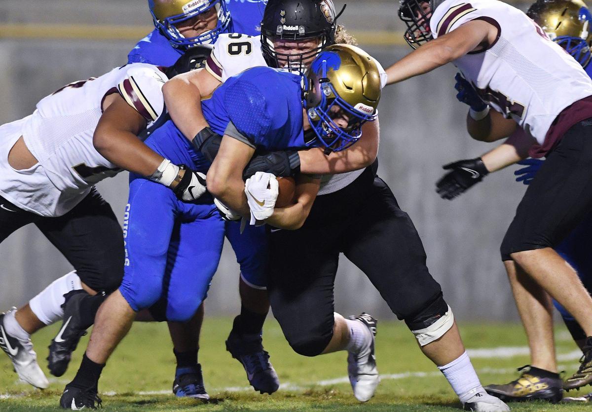 Clovis High’s Tristan Risley, center, fights for yards against the Whitney defense Friday, Sept. 10, 2021 in Clovis.