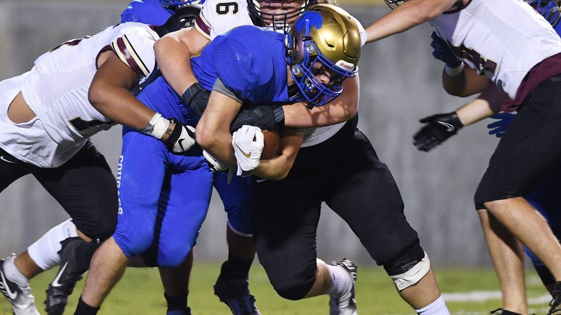 Clovis High’s Tristan Risley, center, fights for yards against the Whitney defense Friday, Sept. 10, 2021 in Clovis.