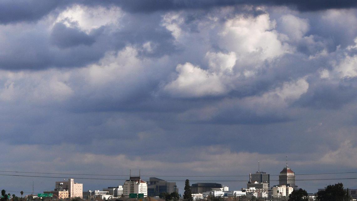 Sun shines through a break in the clouds highlighting the skyline between storms Friday, Dec. 24, 2021 in Fresno.