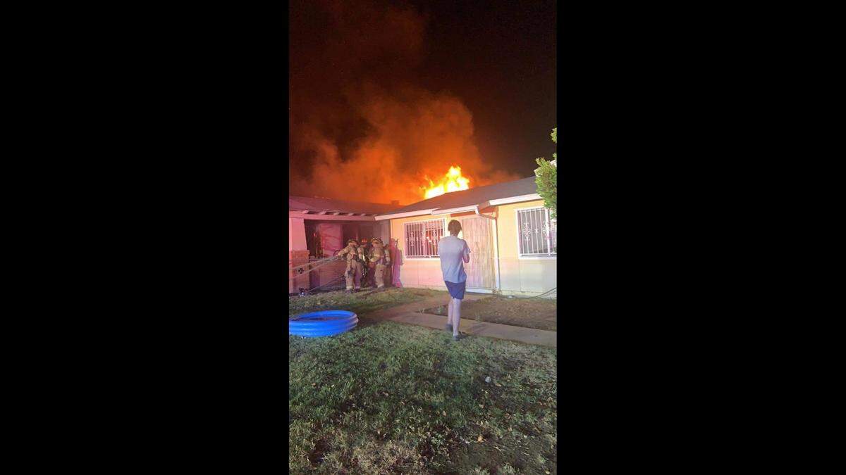 A neighbor took a picture of the flames coming off of the roof after midnight Wednesday, June 29, 2022, from a fatal fire in a Tower District home.