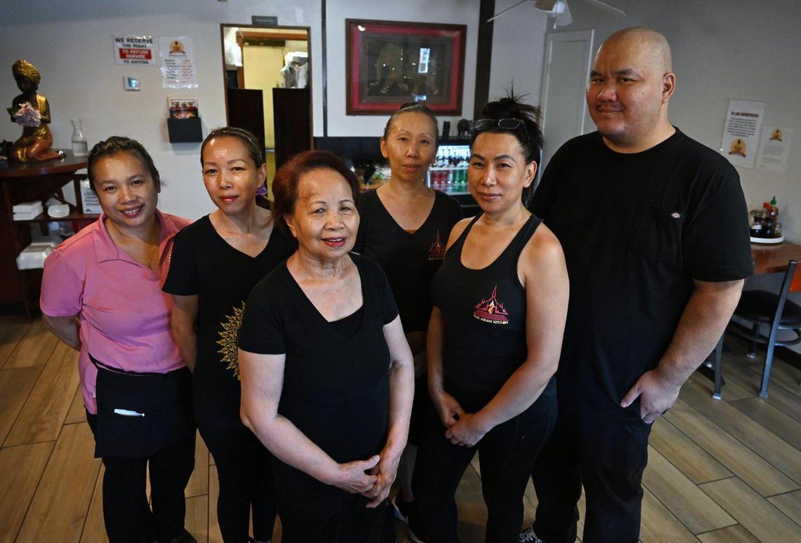 Bone Douangboupha, center, the matriarch of the family, stands in front of family and workers at B&K Asian Kitchen on First Street Wednesday, July 9, 2025 in Fresno. The owners are stepping down after the restaurant has been in business servng Lao and Thai food since 1989.