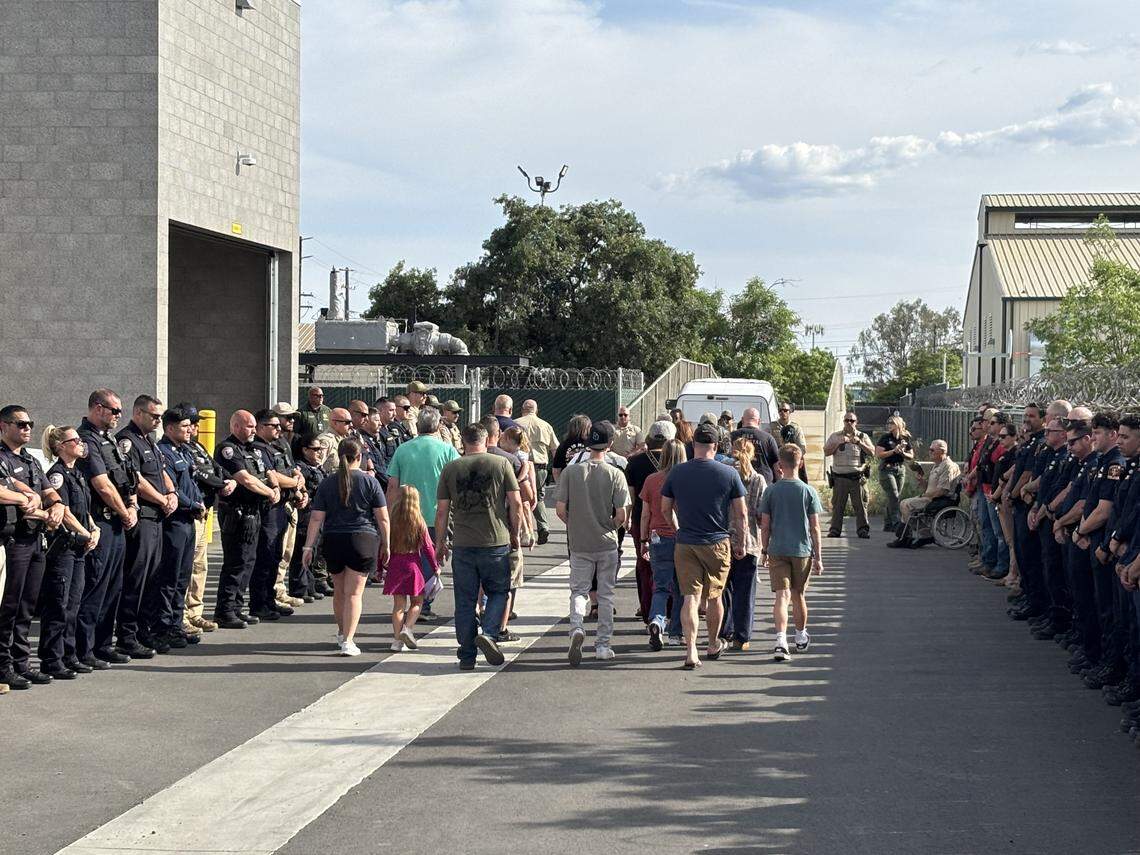 Family members and emergency personnel receive the body of a slain deputy at the Tulare County Coroner’s office in Tulare, California on Thursday, April 9, 2026.