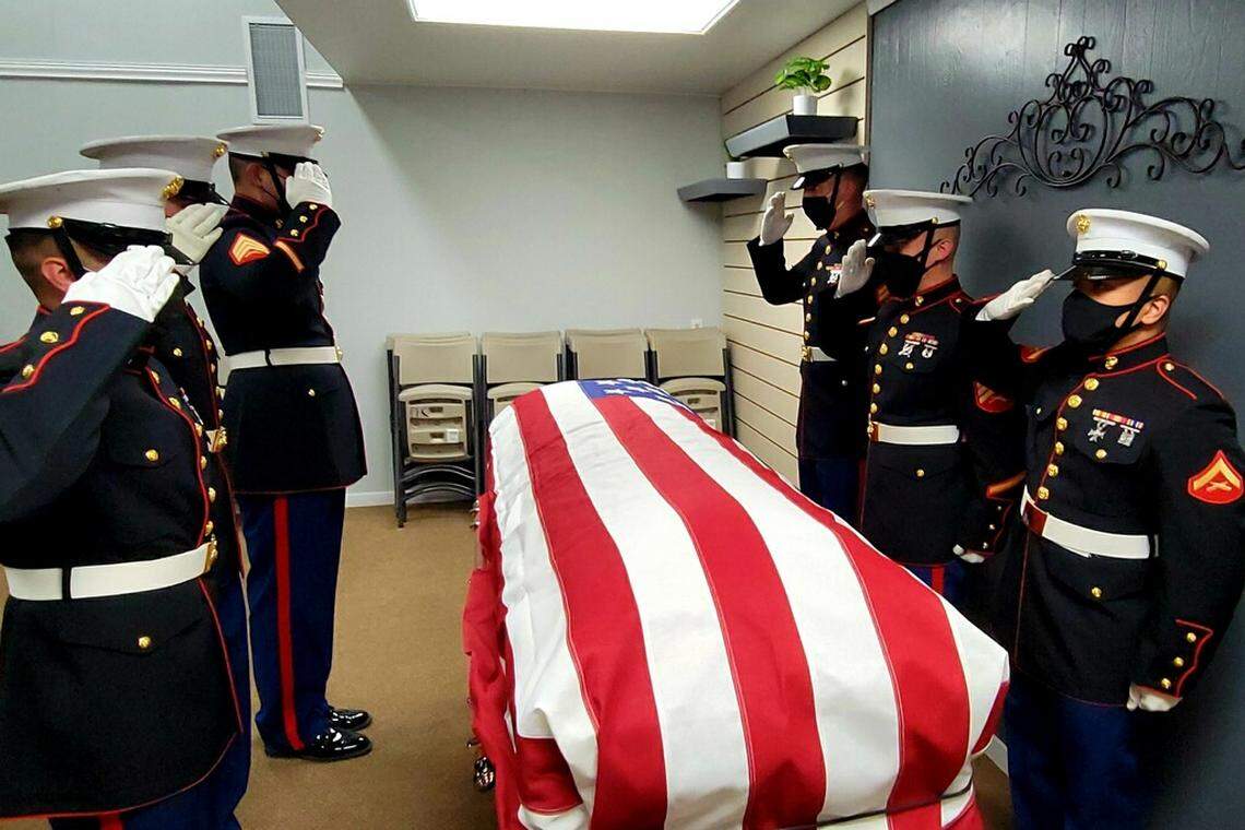 Marine Corps members salute after carrying the casket with Pfc. Royal Waltz’s remains into People’s Funeral Chapel in Hanford.