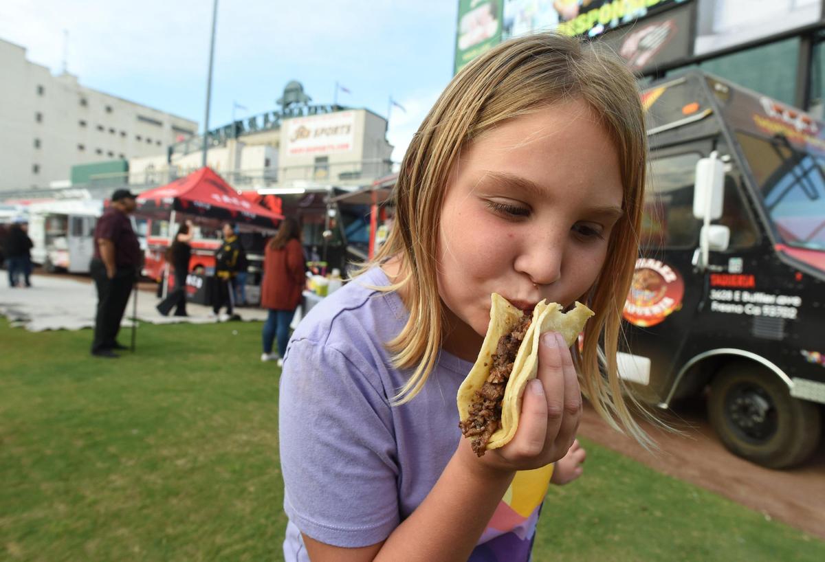 In this file photo from 2021, 8-year-old Gwen Hogenson tries her favorite taco with asada, during the 10th annual Taco Truck Throwdown at Chukchansi Park, Saturday evening, Oct. 23, 2021.
