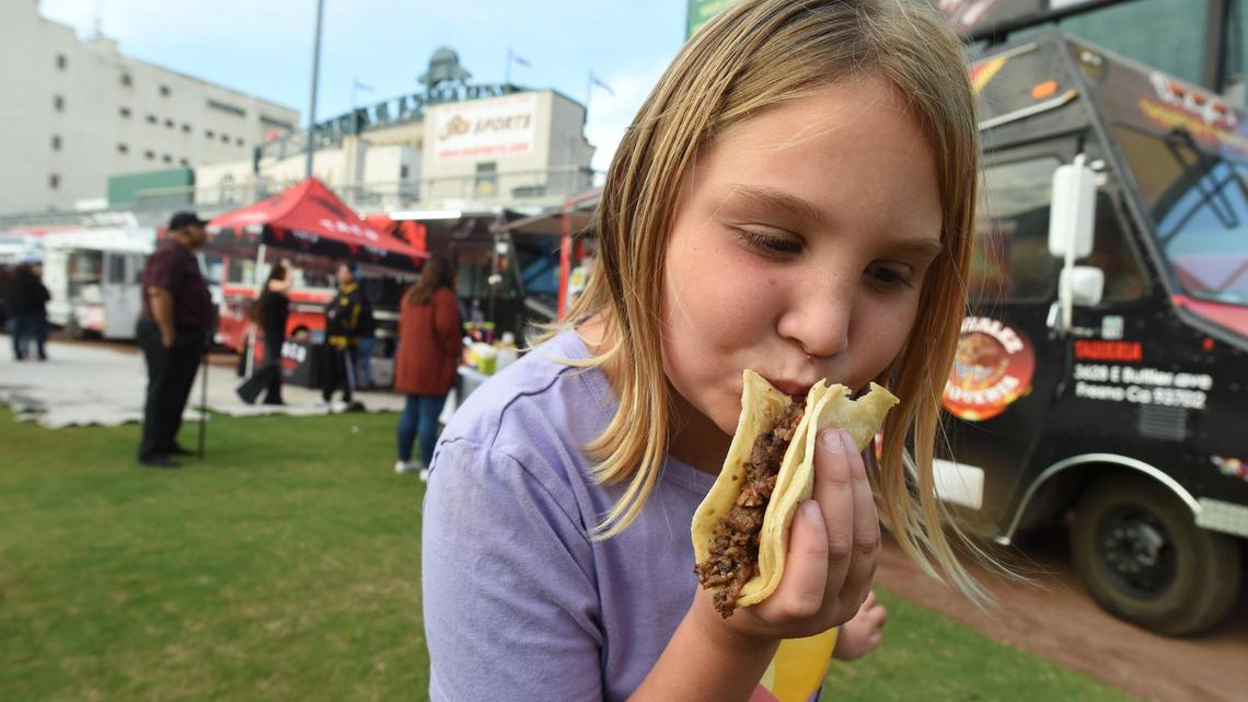 In this file photo from last year, 8-year-old Gwen Hogenson tries her favorite taco with asada, during the 10th annual Taco Truck Throwdown at Chukchansi Park, Saturday evening, Oct. 23, 2021.