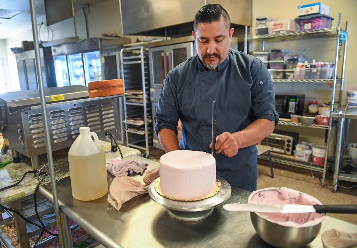 Victor Callejas, of Callejas Cakes in Fresno, frosts a cake at the shop on Tuesday, April 20, 2021.