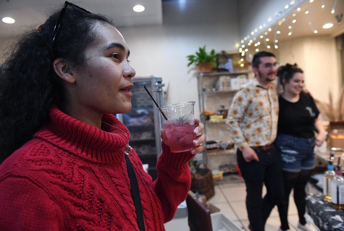 Princess Kosinski, left, of the Wildflower Collective, tastes The Lamplighter, made by Ian Landis, center background, of Bone Dry Sober Bar, located inside Fig & Honey on Fulton Street during Art Hop Thursday, Dec. 2, 2021 in Fresno.