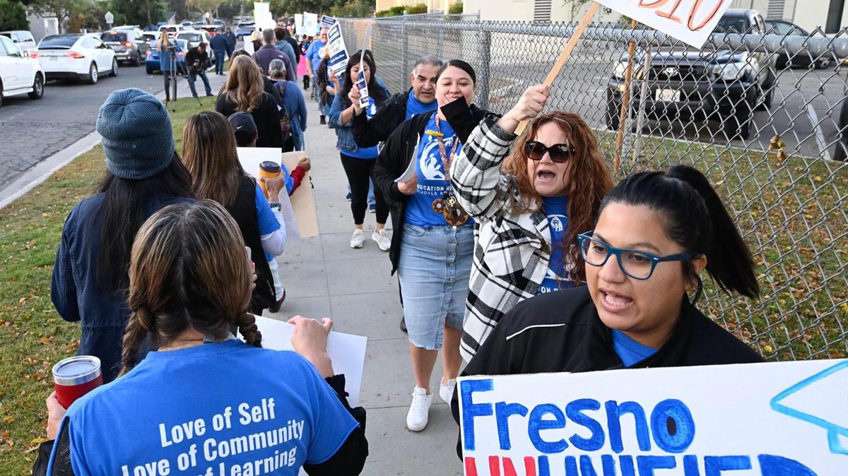 Teachers, supporting parents and their families, numbering close to 100, march in front of Winchell Elementary School in south Fresno as part of Fresno Teachers Association’s Day of Action Friday morning, Oct. 27, 2023 in Fresno. FTA intends to strike on Wednesday Nov. 1 if no agreement is reached.