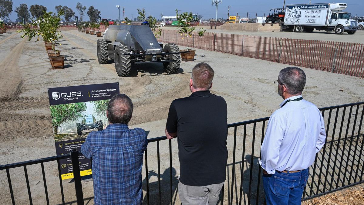 Farm show-goers watch an autonomous ag sprayer from Guss drive through a mock orchard at the World Ag Expo in Tulare on Tuesday, Feb. 8, 2022.
