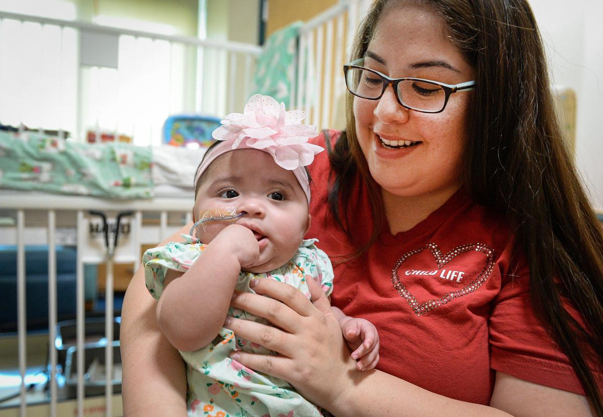 Child Life specialist Marisa Ybarra-Reyes works with Audrey, a 6-month-old, during her stay at Valley Children’s Hospital in Madera.