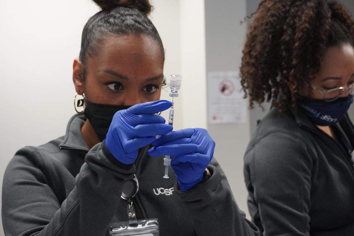 Corina Jefferson, medical assistant with UCSF Fresno’s COVID-19 Equity Project, draws a vaccine.