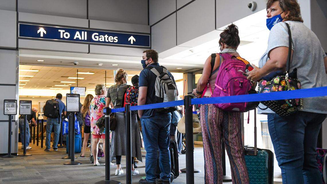 Passengers wait in line to go through the TSA security checkpoint at Fresno Yosemite International Airport on Tuesday, June 29, 2021.