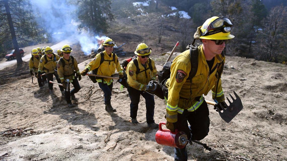 Cal Fire firefighters proceed up a cleared hill after burning downed dead trees and brush near Meadow Lakes on Wednesday, Feb. 10, 2021. Cal Fire firefighters are taking a 7.5% pay cut Gov. Gavin Newsom’s administration negotiated when it anticipated a severe recession in the coronavirus pandemic.