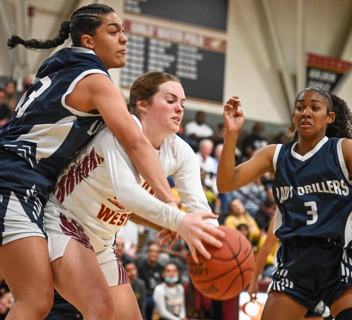 Clovis West’s Kennedy Vincent, center, tires to grab a rebound away from Bakersfield’s Faith Curry during their Central Section Open Division championship game at Clovis West on Saturday, Feb. 26, 2022.