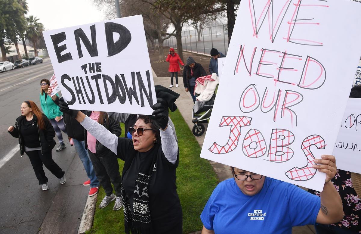Customer service representative Maria Diaz, bottom center, and tax examiner Kendra Salinas, bottom right, joined a crowd of about 125 IRS employees for a rally against the government shutdown outside the Fresno IRS Processing Center Thursday morning, Jan. 10, 2019 in Fresno.