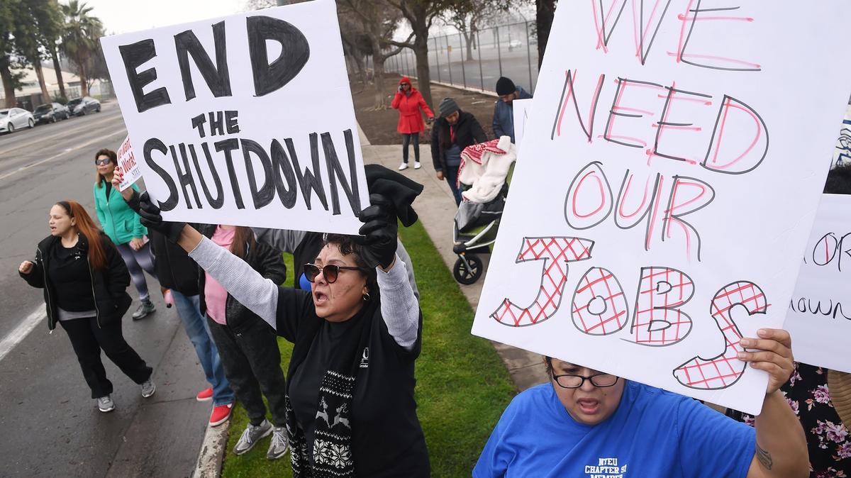 Customer service representative Maria Diaz, bottom center, and tax examiner Kendra Salinas, bottom right, joined a crowd of about 125 IRS employees for a rally against the government shutdown outside the Fresno IRS Processing Center Thursday morning, Jan. 10, 2019.