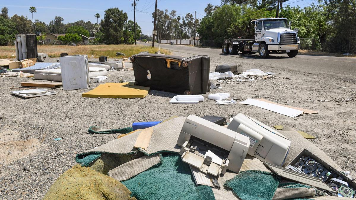 An illegal dump, including appliances, mattresses, computer equipment, furniture and chemical containers, is shown strewn along the roadside at the corner of McKinley Avenue at Bryan west of Fresno on Friday, April 30, 2021.