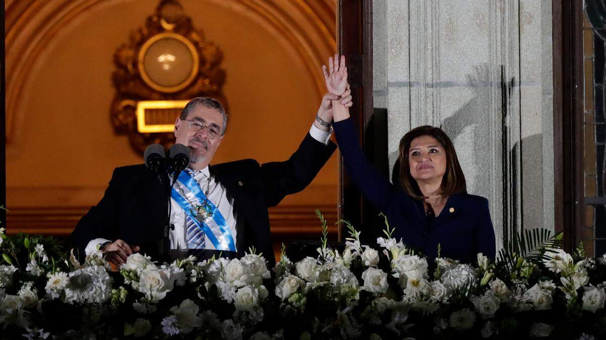 El presidente de Guatemala, Bernardo Arévalo de León, y la vicepresidenta Karin Herrera saludan desde el Palacio de Gobierno en la madrugada del 15 de enero en Ciudad de Guatemala.