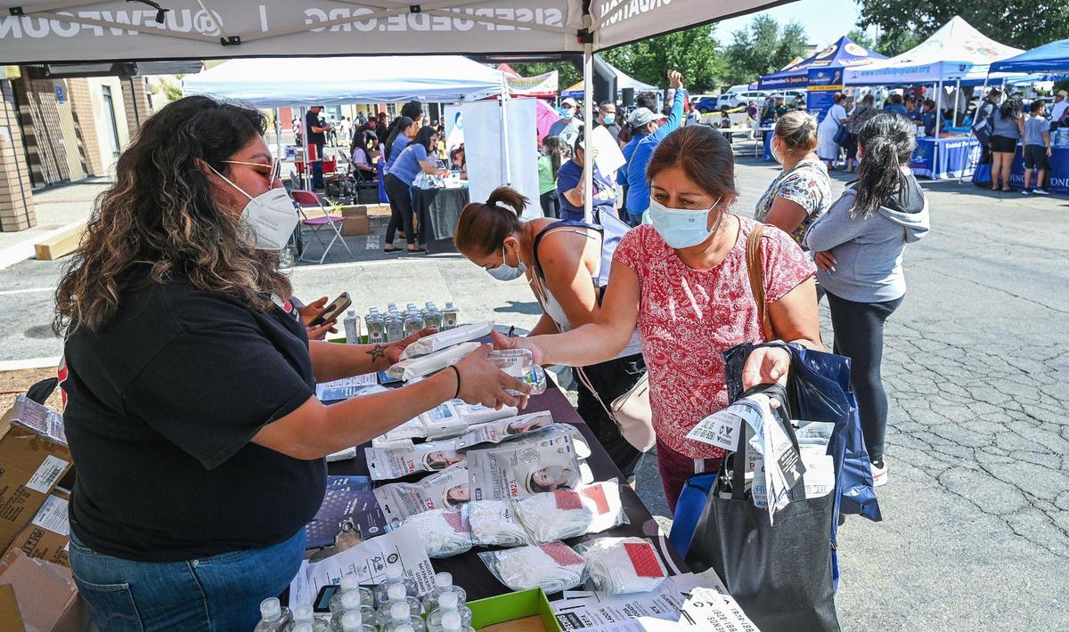 Parents pick up personal protective equipment, sanitizers and other safety supplies during a backpack and school supplies giveaway for the new school year at United Way Fresno and Madera Counties in Fresno on Saturday, Aug. 6, 2022.