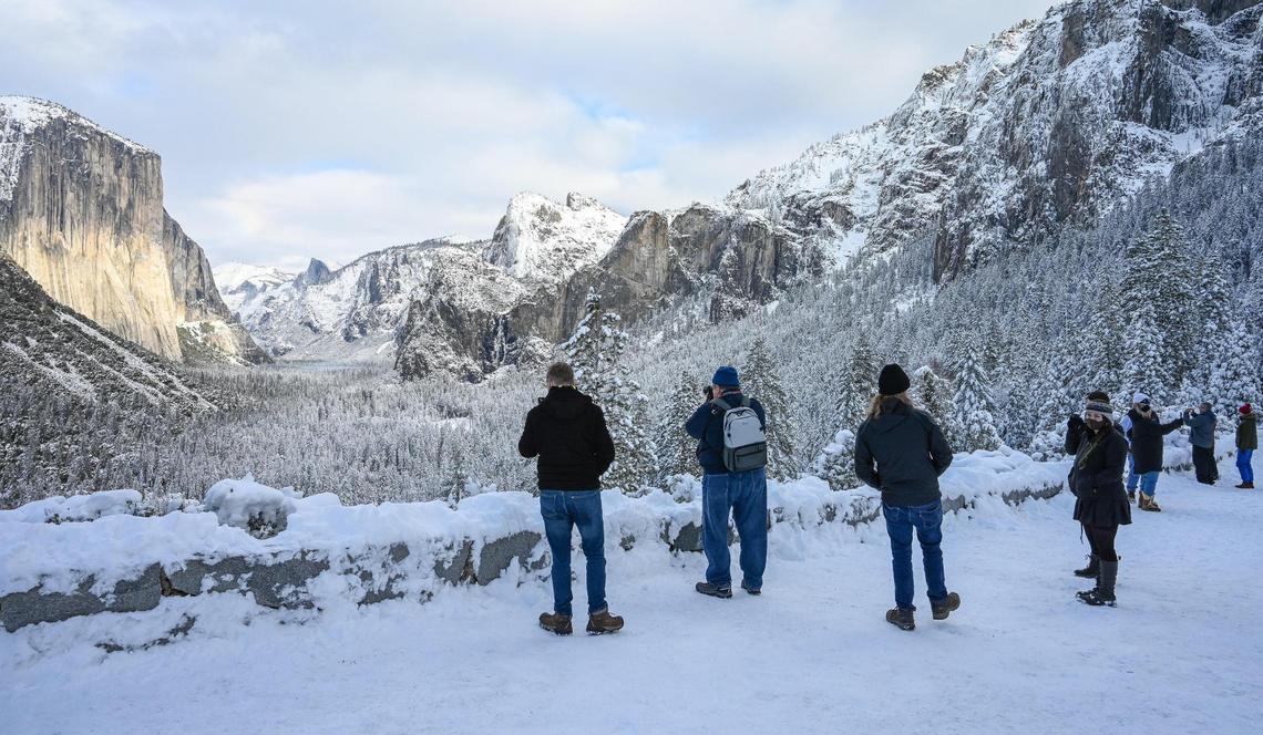 Yosemite National Park visitors take in the sites of the snow-covered valley at Tunnel View in Yosemite on Wednesday, Dec. 15, 2021, following a snowstorm the day before.