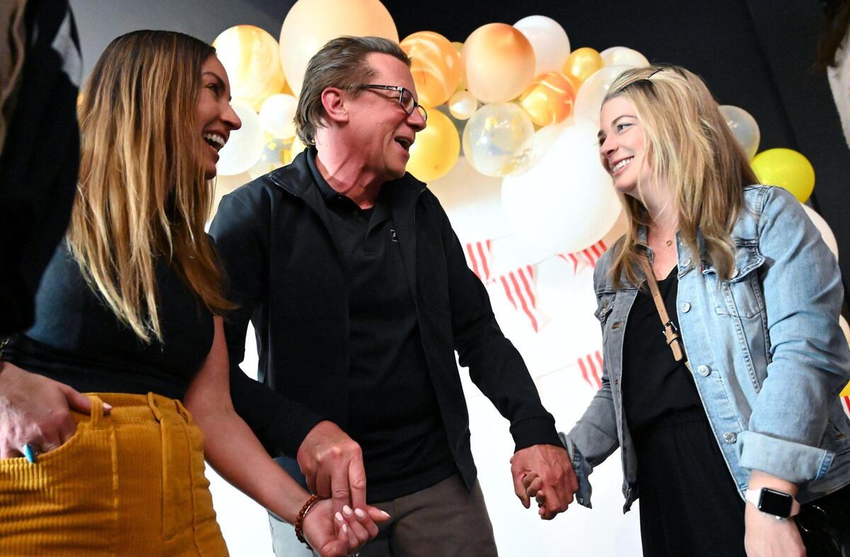 Former students and 2001 graduates Amy Sherfy, left, and Bethany Oleander, right, greet Fresno Christian journalism adviser Greg Stobbe after he was honored with the Columbia Scholastic Press Association’s Charles R. O’Malley Award for excellence in teaching at a surprise party Friday night, April 29, 2022 in Fresno. As part of the over 2 hour program, students inspired by Stobbe in the past sent video messages of gratitude and appreciation, displayed on a large screen to about 100 attendees in the Student Ministry Center at Fresno Christian.