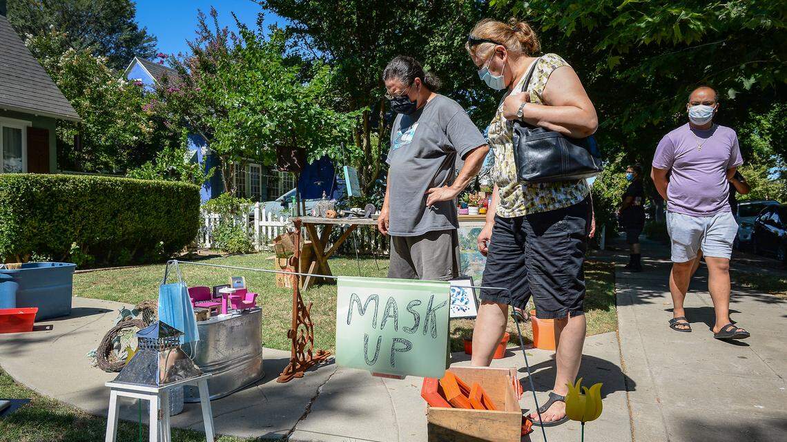 Customers check out merchandise being sold at a homeowner’s yard sales during the annual Harvard block sale in Fresno on Saturday, July 11, 2020. The sale was moved from May due to the coronavirus pandemic, but was still discouraged by city officials.