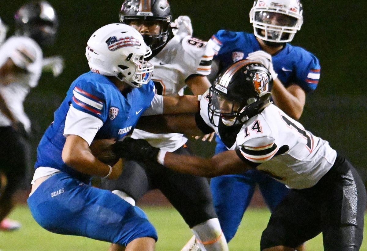 Buchanan quarterback Logan Sanchez, left, is swarmed by the Central defense including Jeremiah Cooks, right, and Jose Aguilar, background, as he’s sacked in first half action Thursday, Oct. 5, 2023 in Clovis.