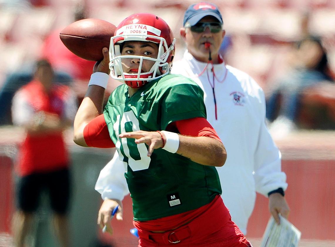 Fresno State quarterback Jorge Reyna fires a pass under the watchful eye of coach Jeff Tedford.