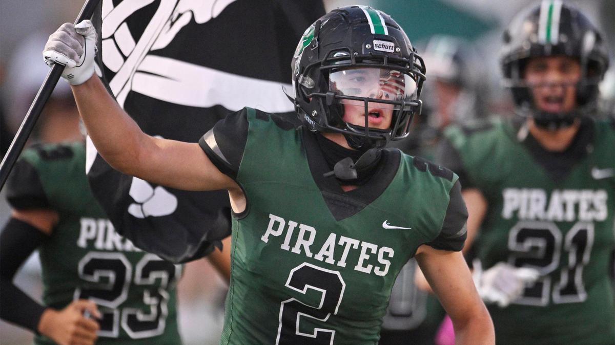 Reedley’s Malachi Rios carries a pirate flag into the stadium at the start of the game against Roosevelt, his last game before undergoing chemotherapy for a second time Friday night, Aug. 25, 2023 in Reedley.