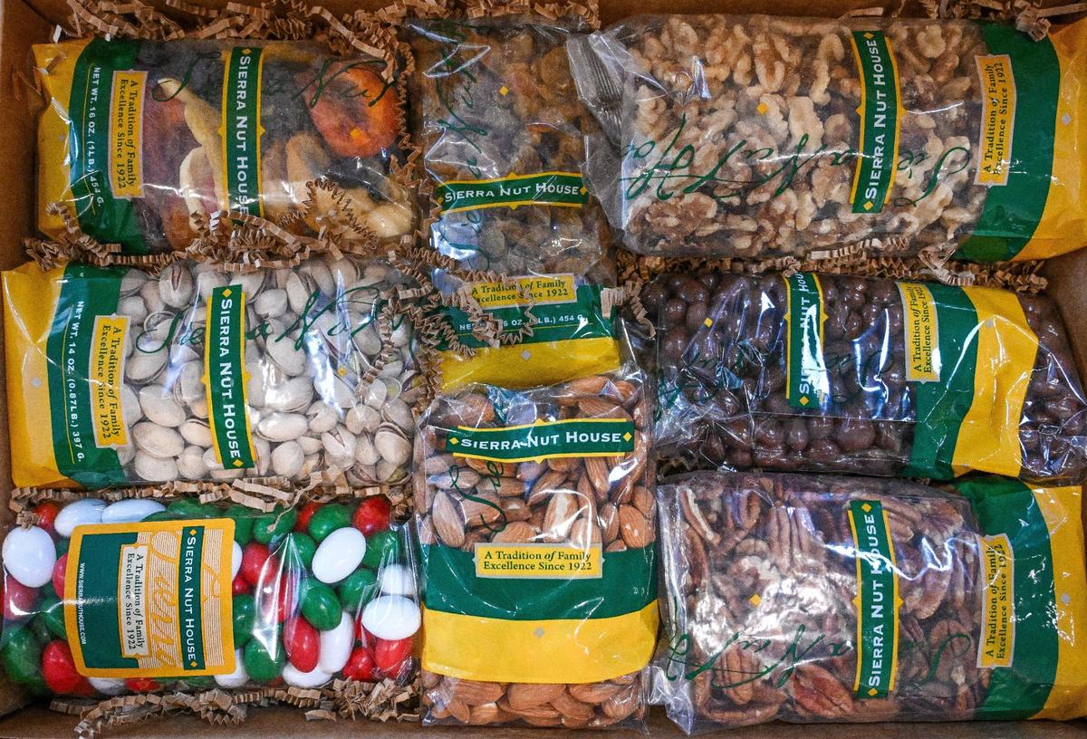 Packages of various nuts, fruits and chocolates are tucked into a shipping box at the Sierra Nut House, which recently opened in a new location on Pollasky Avenue in Old Town Clovis.